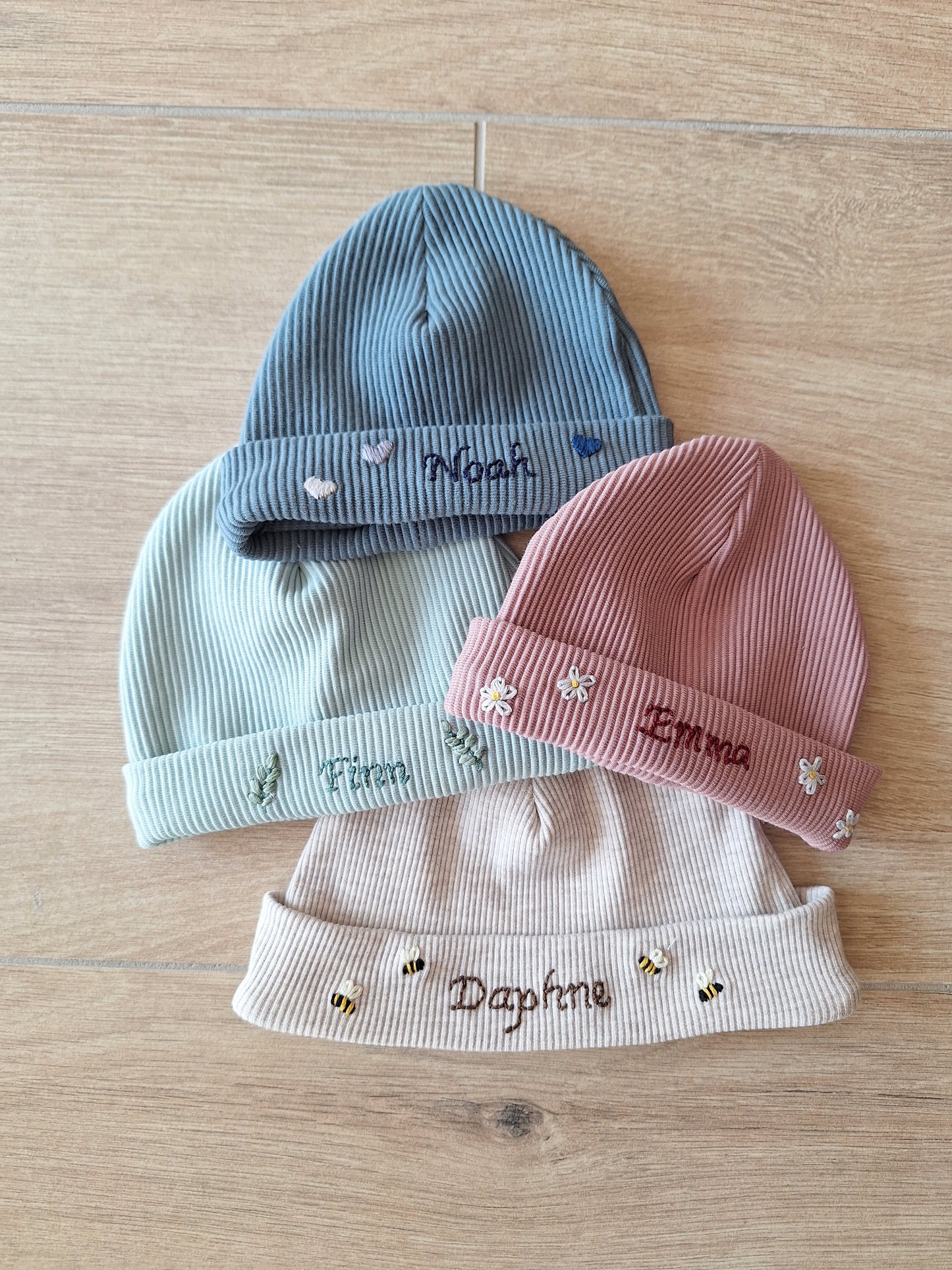 Handgeborduurd babymutsje met naam en decoratie