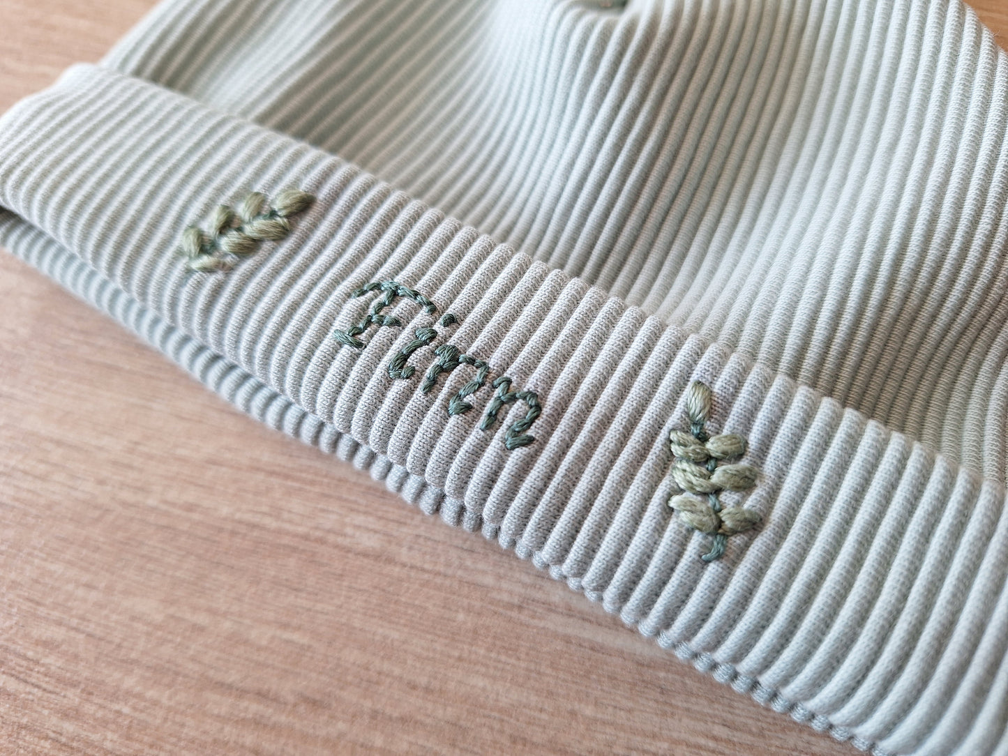 Handgeborduurd babymutsje met naam en decoratie