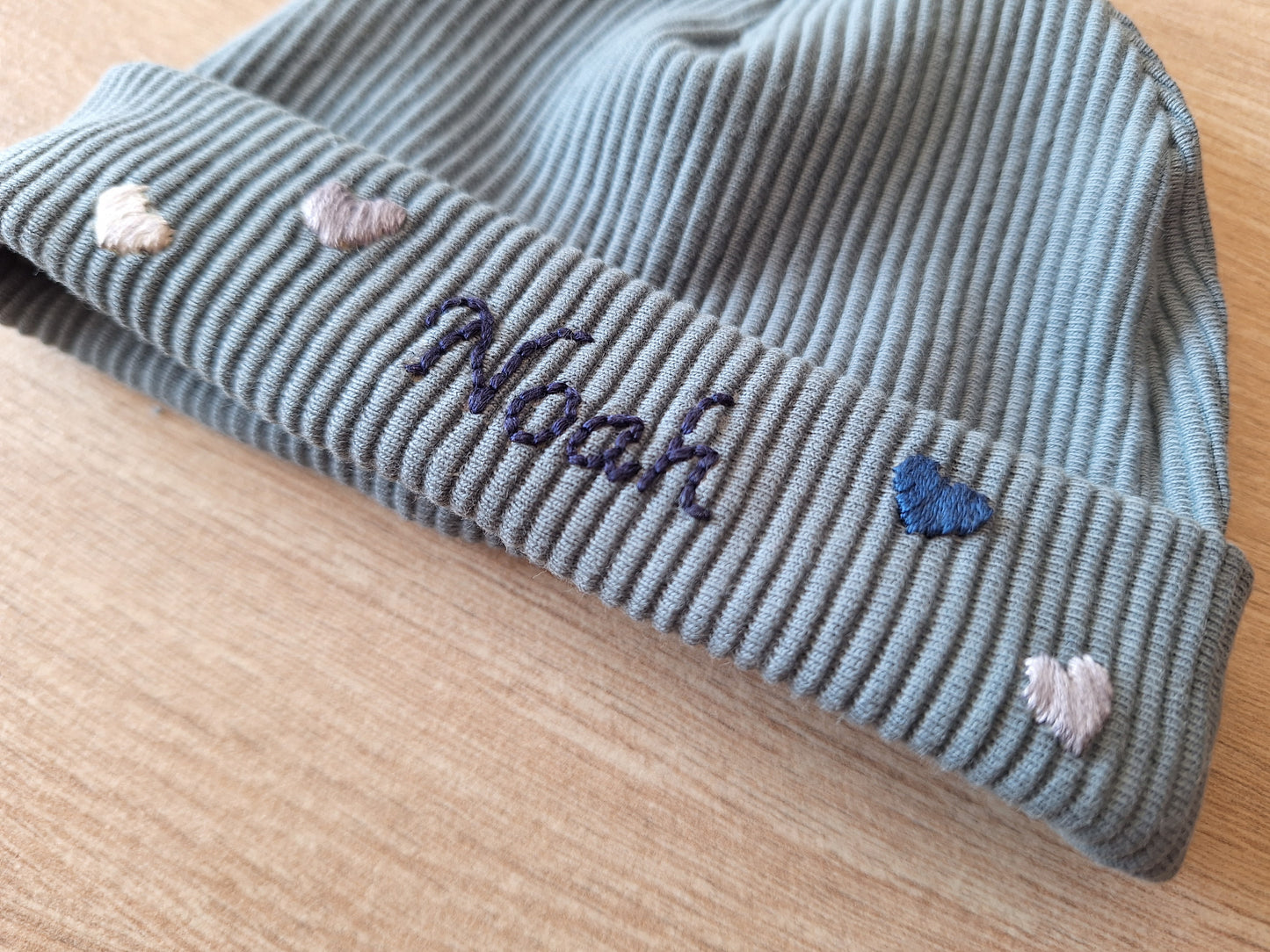 Handgeborduurd babymutsje met naam en decoratie
